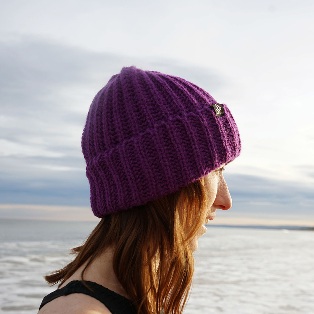 woman on beach in purple oss beanie