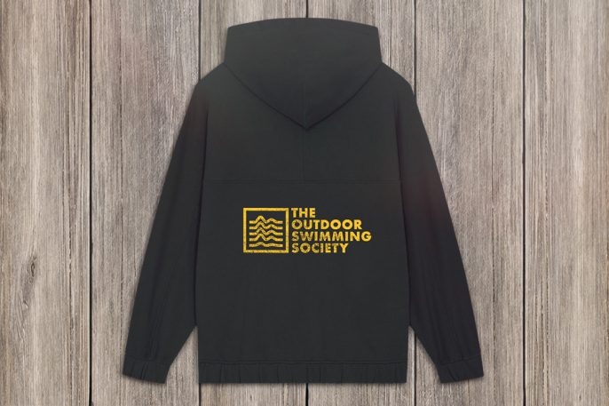 black oversized hoodie back view with large logo with The Outdoor Swimming Society on the back