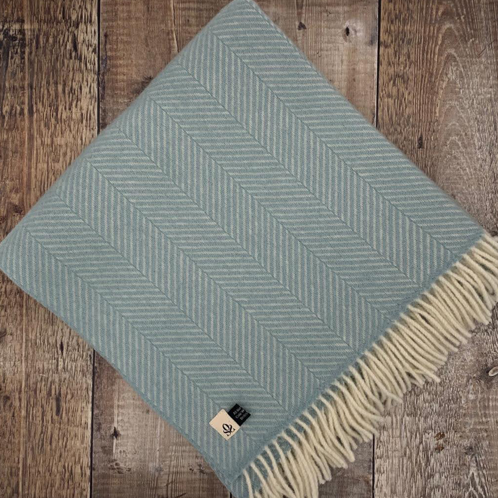 duck egg blue blanket with fishbone pattern folded with tassled edge