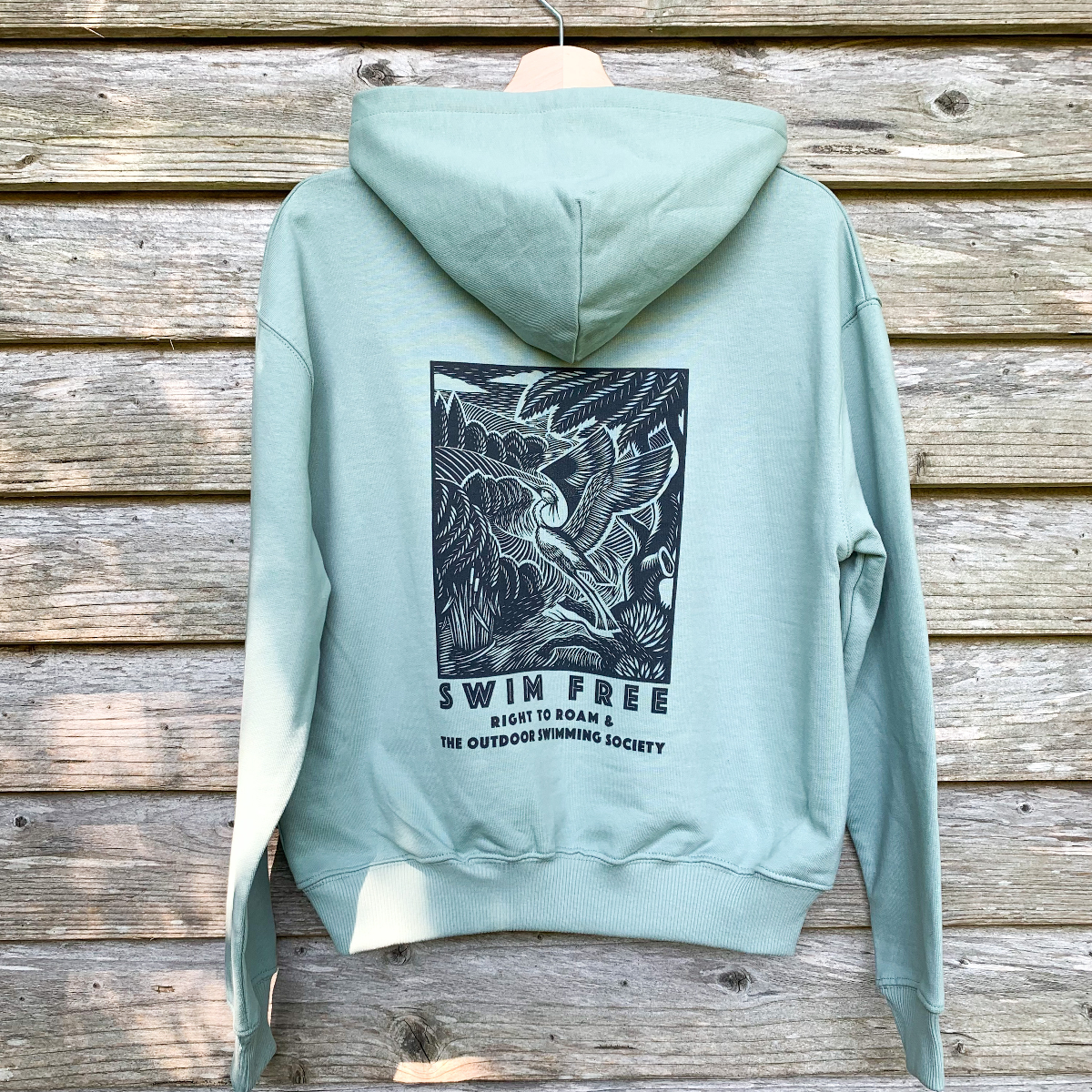 Aloe green Right to Roam hoodie back view on hanger