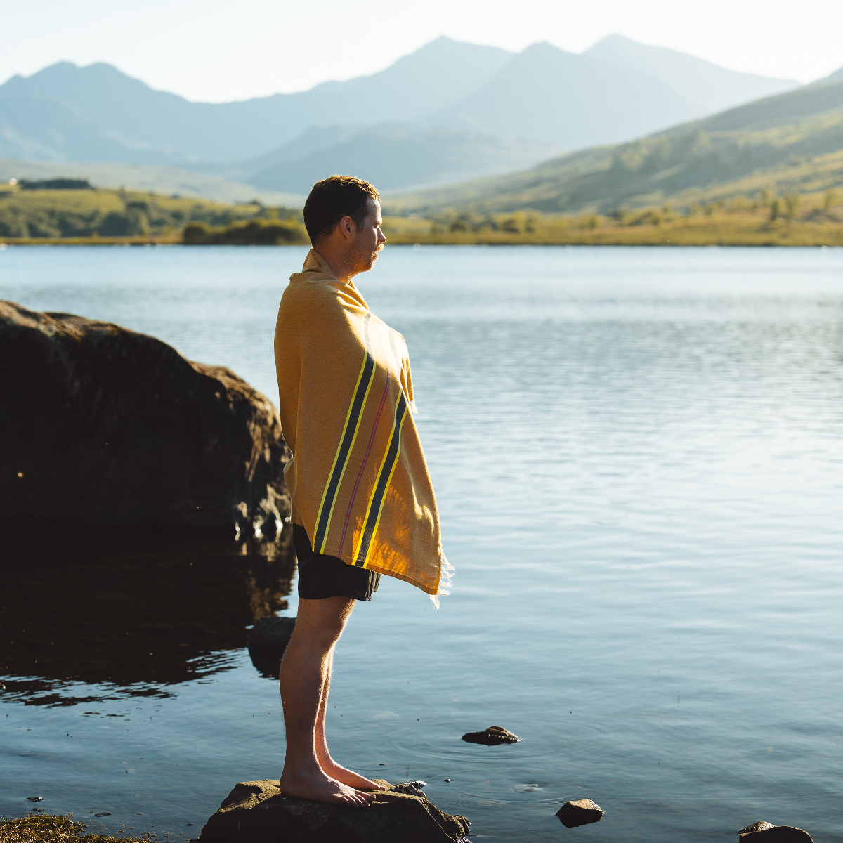 Hollie Harmsworth Man wrapped in an OSS striped hammam towel, standing by a lake
