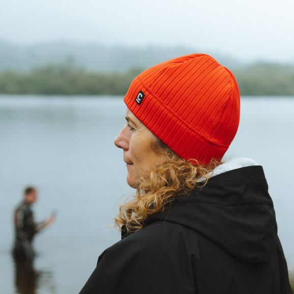 Side view of a woman wearing a red storm chaser beanie