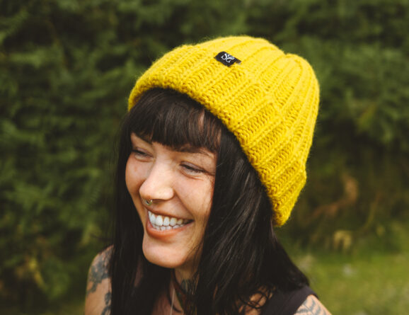 Woman wearing a yellow OSS beanie