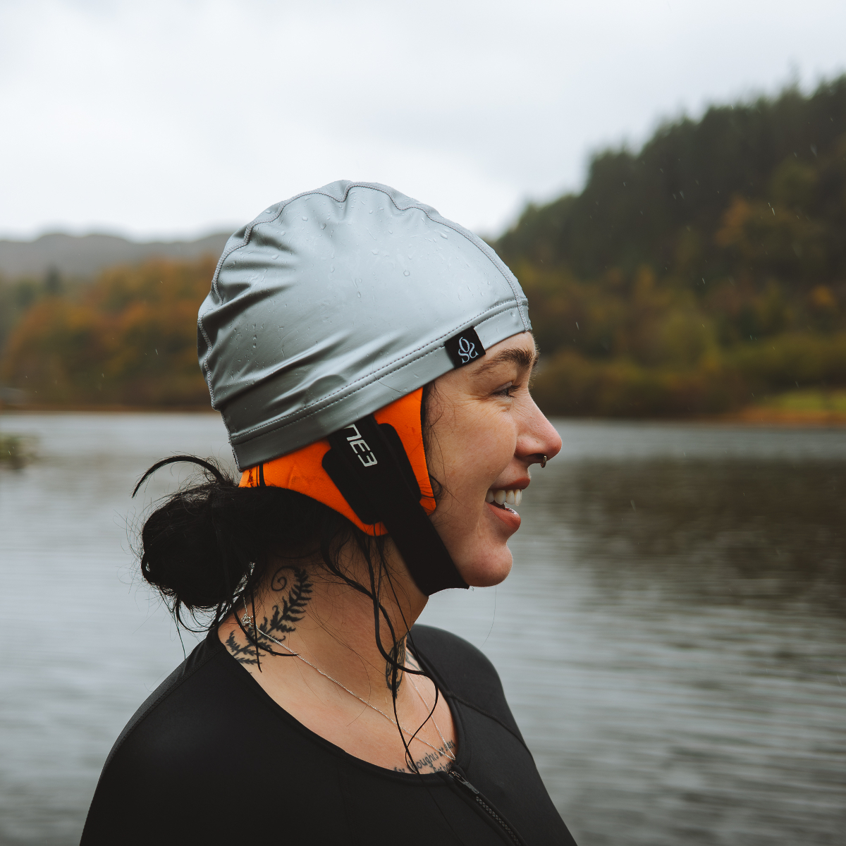 Hollie Harmsworth Woman in a silver swimming cap with a neoprene bonnet underneath