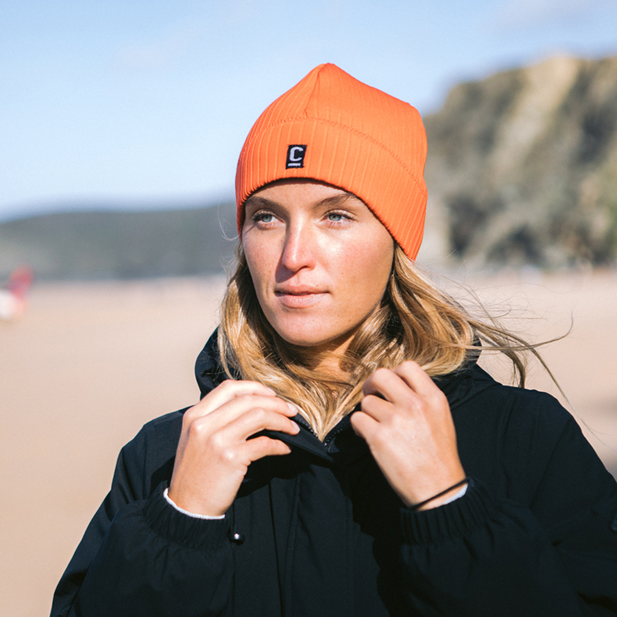 CJB Surf/C-Skins Woman wearing a storm chaser beanie in red