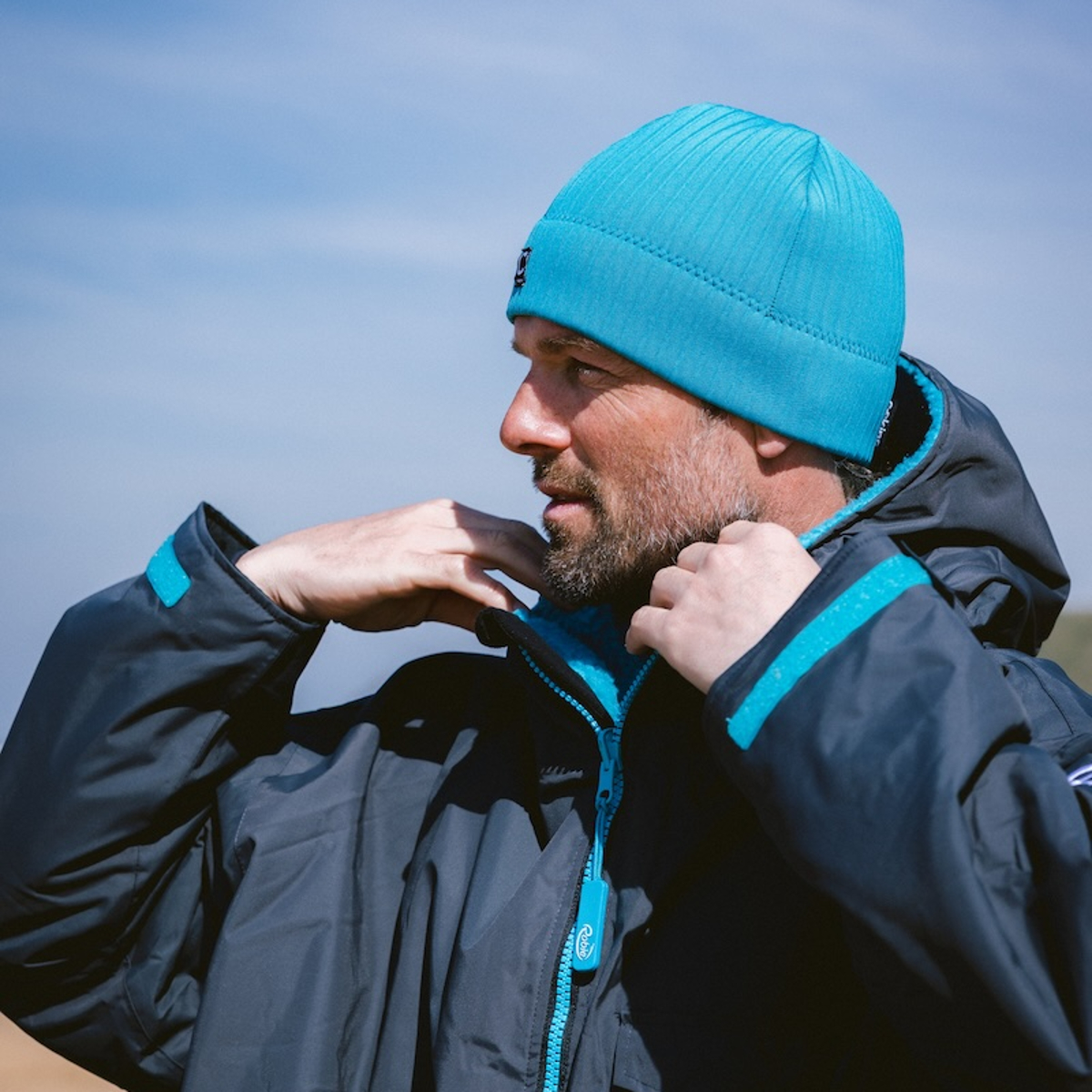 CJB Surf/C-Skins Man wearing a storm chaser beanie in teal viewed from the side